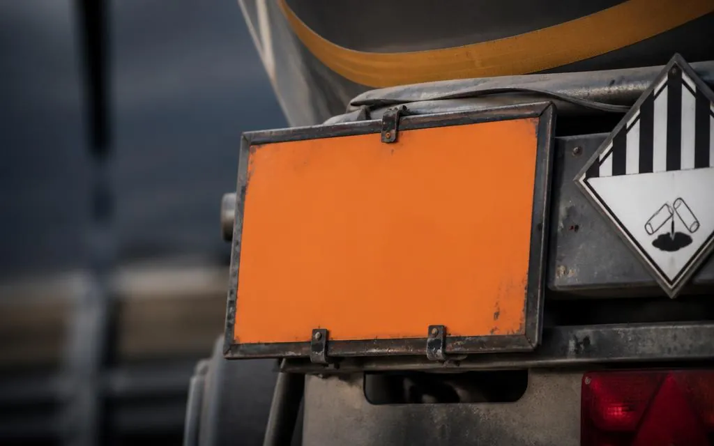 Orange Gefahrguttafel und Gefahrzettel am Heck eines Aufliegers